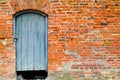 The texture of the old ancient medieval antique solid wooden thick door against the background of a stone wall of red brick Royalty Free Stock Photo