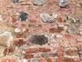 The texture of the old ancient medieval antique stone hard peeling cracked brick wall of rectangular red clay bricks and large st Royalty Free Stock Photo