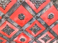 Texture of an old ancient medieval red antique sturdy iron metal door with rivets and nails patterns. The background Royalty Free Stock Photo