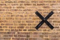 Texture of old brick wall with a black metal cross on it Royalty Free Stock Photo