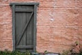 Texture of an old brick wall with a door from boards, copy space. Red brick wall background of retro house Royalty Free Stock Photo