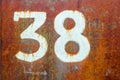 Texture of completely rusty metal with number thirty eight drawn by white paint