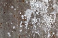 Texture of an old concrete wall with loose plaster and drops of white paint