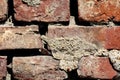 Texture of old cracked dilapidated red bricks wall partially covered with dry concrete mixed with small grain gravel Royalty Free Stock Photo