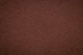 Texture of old dark brown paper background, closeup. Structure of dense umber cardboard