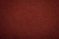 Texture of old dark red paper background, closeup. Structure of dense maroon cardboard