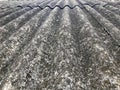 Texture of old dilapidated bulk gray slate, sloping roof of asbestos located vertically covered with green moss Royalty Free Stock Photo