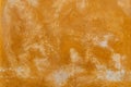 Texture of an old orange plastered street wall. old wall with peeling paint, scratched stained plaster. Royalty Free Stock Photo
