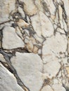 The texture of an old stone wall with pieces of white marble and gray pebbles, with cracks and veins Royalty Free Stock Photo