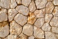 Texture of an old stone yellow wall from uneven different ancient friable stones of different shapes with sandy seams. The backgro