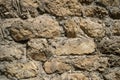 Texture of old stones of various forms with seams. Close up of shabby masonry. Stone wall from uneven different ancient