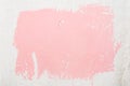 Texture of an old uneven white wall with an abstract spot of pink color, painted with a brush using dispersion