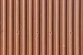 Texture of an old wave-shaped metal sheet painted in brown with screws in it Royalty Free Stock Photo