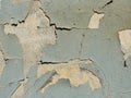 A layer of peeling old blue paint on the relief surface of a concrete cement wallTexture of old white cracked paint on blue concre Royalty Free Stock Photo