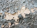 A layer of peeling old blue paint on the relief surface of a concrete cement wallTexture of old white cracked paint on blue concre Royalty Free Stock Photo