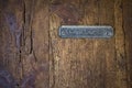 Texture of an old wooden door, rural texture with a recessed metal mailbox with the text in spanish cartas, letters