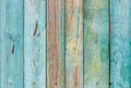 The texture of an old wooden fence with weathered boards painted with peeling paint in a muted emerald green color Royalty Free Stock Photo