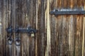 Texture of an old wooden gate with a large lock.