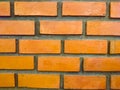 The texture of orange brick wall. They are arranged in rows, alternating beautifully. Around each brick is surrounded by gray