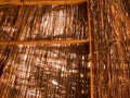 texture of an orange brown natural dry straw shimmered in the sun roof of a thatched old bungalow. Natural decorative background Royalty Free Stock Photo