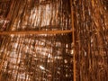 Texture of an orange dry straw shimmered in the sun roof of a thatched old bungalow. Natural decorative background Royalty Free Stock Photo