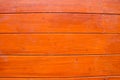 The texture of orange wood floor. They are arranged in rows beautifully. It is a beautifull patterned surface with shiny dark