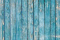 The texture of a painted shabby wooden fence with cracked blue-green paint