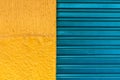 Texture pattern of cyan iron door of closed store and yellow wal