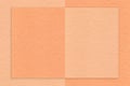 Texture of peach fuzz and coral paper background with geometric shape, macro. Structure of craft cardboard
