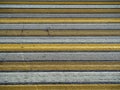The texture of the pedestrian crossing. White and yellow lines alternate on the pavement. Royalty Free Stock Photo