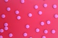 Texture of pink pills on a red background.