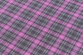 texture of pink and gray tartan fabric close-up at an angle. Background for your design. Traditional Scottish clothing and style