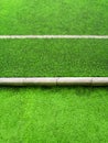Texture of plastic artificial grass and concrete border of school yard