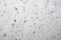 Texture of rain drops on window glass over blur and cloudy sky background Royalty Free Stock Photo