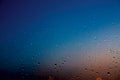 Raindrops on the glass in blue and orange. Royalty Free Stock Photo