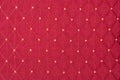 Texture of red fabric with rombic pattern with white dot
