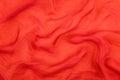 Texture of the red soft chiffon fabric with folds. Closeup of rippled red silk fabric Royalty Free Stock Photo