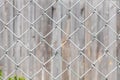Texture of Rhombic cells of a white metal lattice is in the sunny day in the summer park on the gray wood background