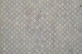 The texture of a rhythmic mosaic made of concrete tiles. Background image of a large area of old and damaged gray tile Royalty Free Stock Photo