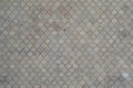 The texture of a rhythmic mosaic made of concrete tiles. Background image of a large area of old and damaged gray tile Royalty Free Stock Photo