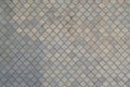 The texture of a rhythmic mosaic made of concrete tiles. Background image of a large area of old and damaged gray tile