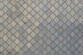 The texture of a rhythmic mosaic made of concrete tiles. Background image of a large area of old and damaged gray tile Royalty Free Stock Photo