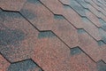 The texture of the roof with bituminous coating. Rough bituminous mosaic of red and brown flowers. Waterproof roofin Royalty Free Stock Photo