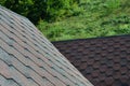 The texture of the roof with bituminous coating. Rough bituminous mosaic of red and brown flowers. Waterproof roofin Royalty Free Stock Photo