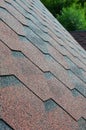 The texture of the roof with bituminous coating. Rough bituminous mosaic of red and brown flowers. Waterproof roofin Royalty Free Stock Photo