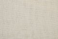 Texture of rough linen fabric beige color, closeup.