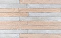 Texture of a rough stone wall made of gray and beige rectangular blocks