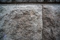 Texture of a rough stone wall made of gray granite blocks