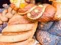 Texture of ruddy brown wheat lush tasty white loaves, bread, black poppy buns. The background