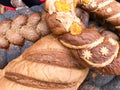 Texture of ruddy brown wheat lush tasty white loaves, bread, black poppy buns. The background